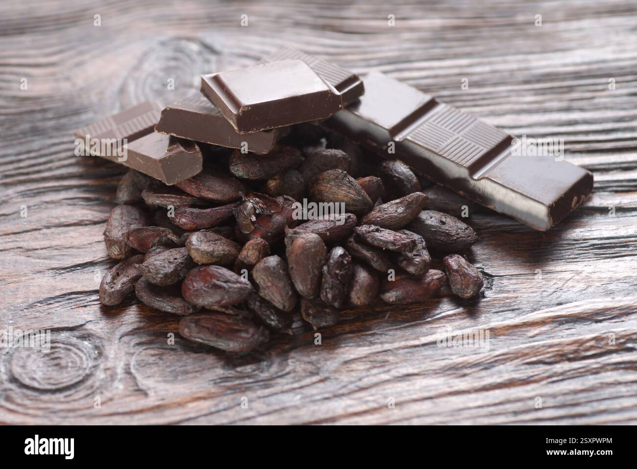 Broken dark chocolate and cocoa beans on the table Stock Photo