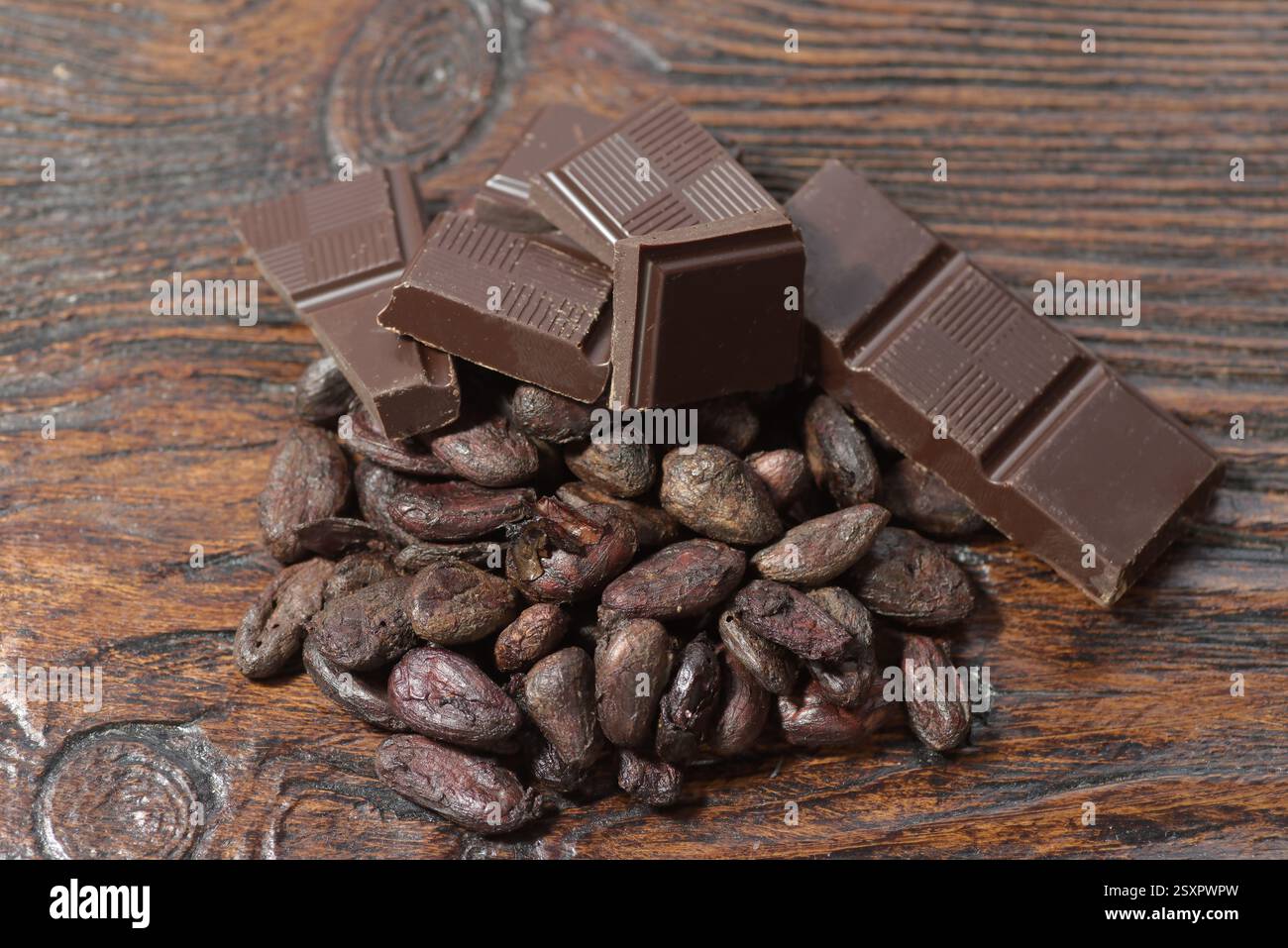 Broken dark chocolate and cocoa beans on the table Stock Photo