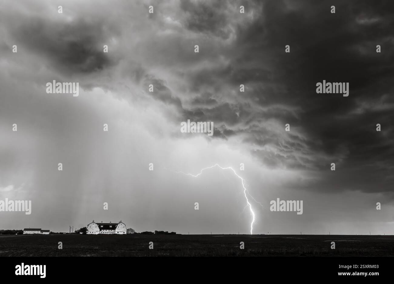 Lightning bolt illuminating the sky above a farmhouse during a powerful ...