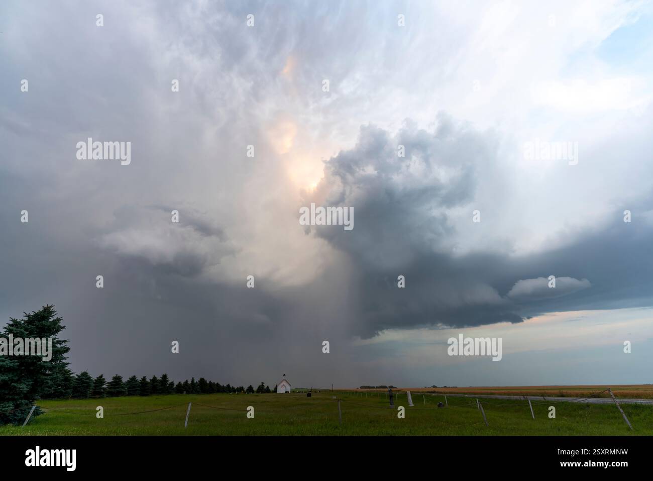 Dramatic storm clouds gathering over a rural landscape with a small ...
