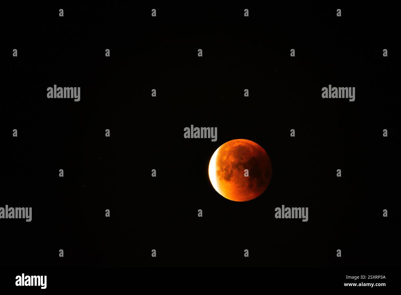 A glowing blood moon during a partial lunar eclipse at night. Stock Photo