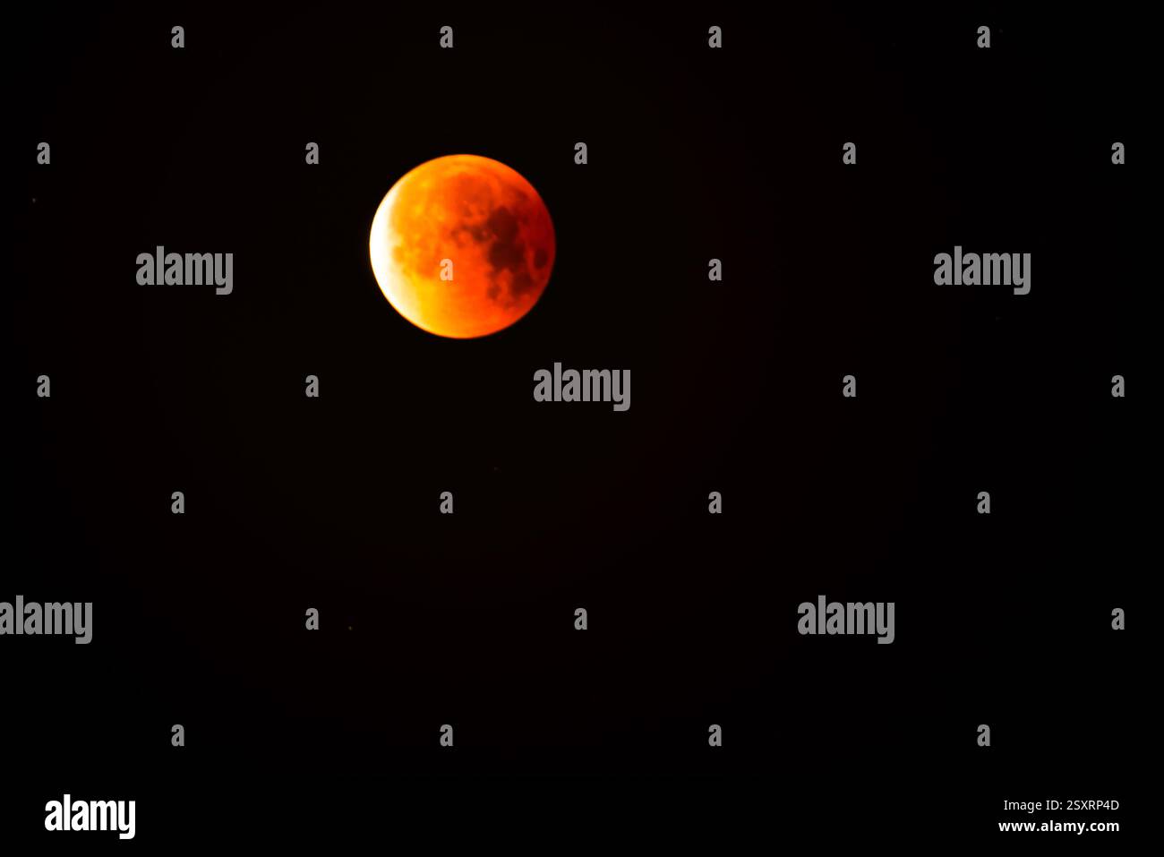 A glowing blood moon during a partial lunar eclipse at night. Stock Photo