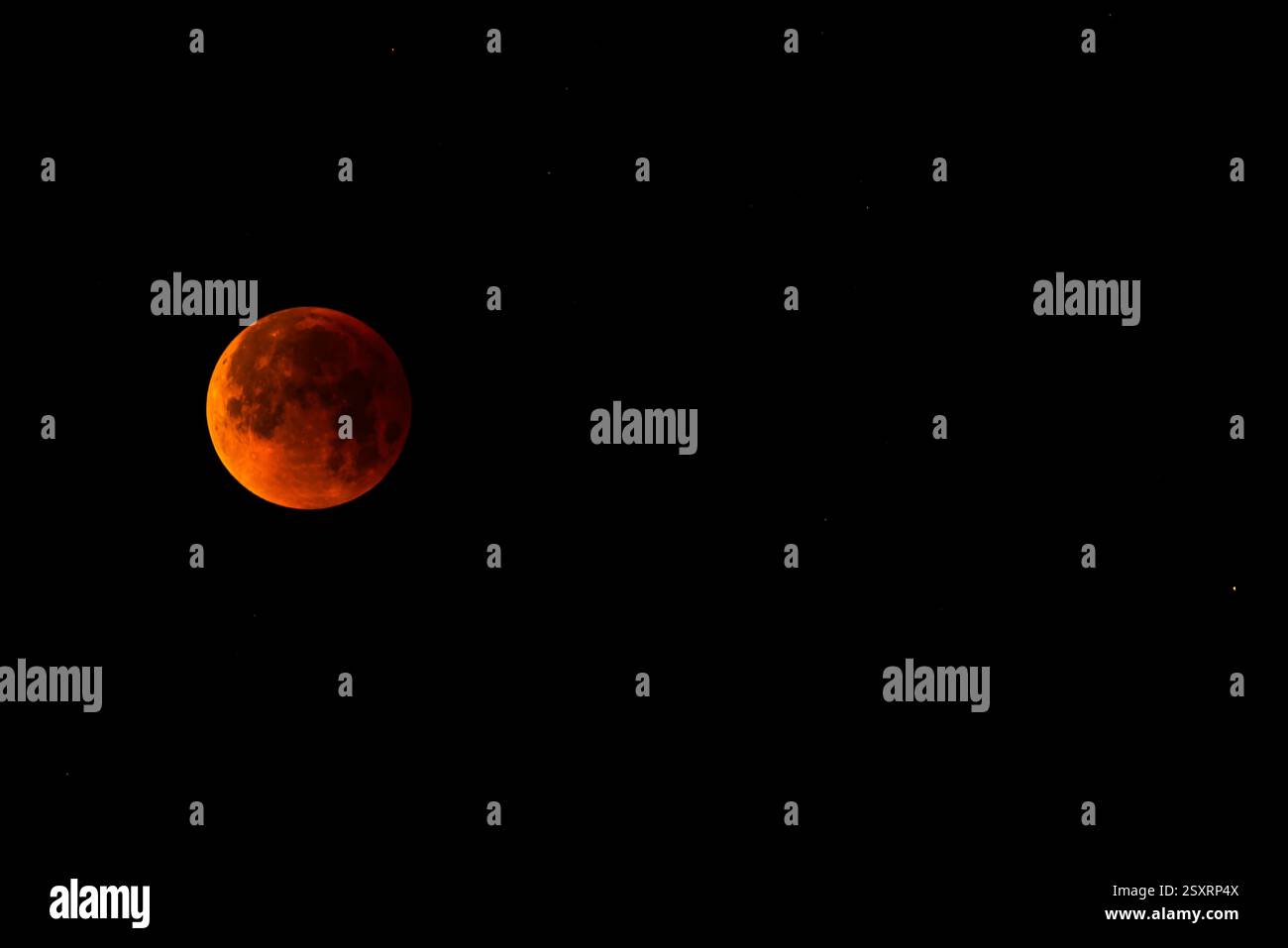 A glowing blood moon during a partial lunar eclipse at night. Stock Photo