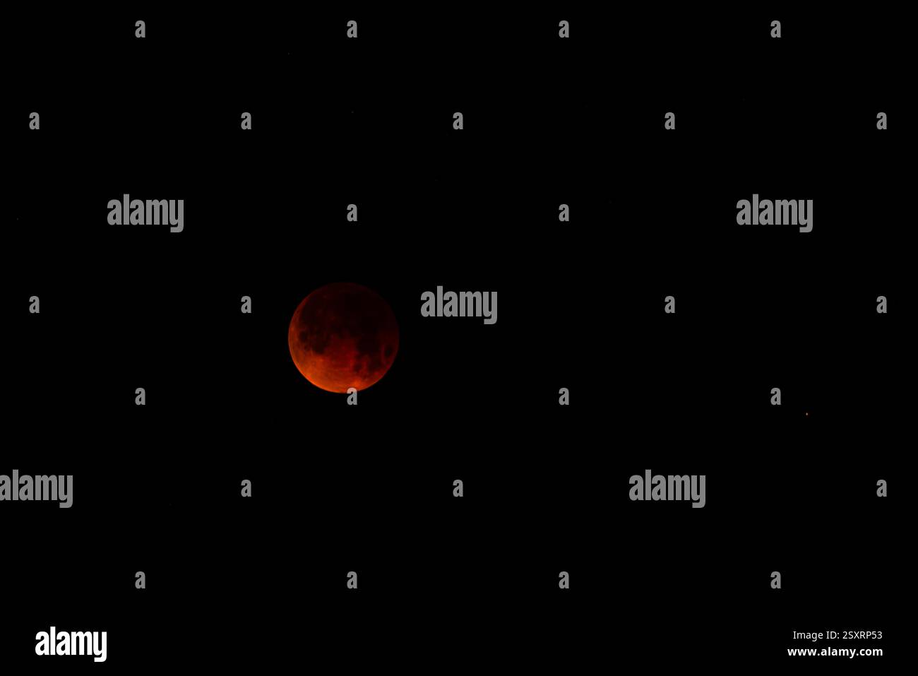 A glowing blood moon during a partial lunar eclipse at night. Stock Photo