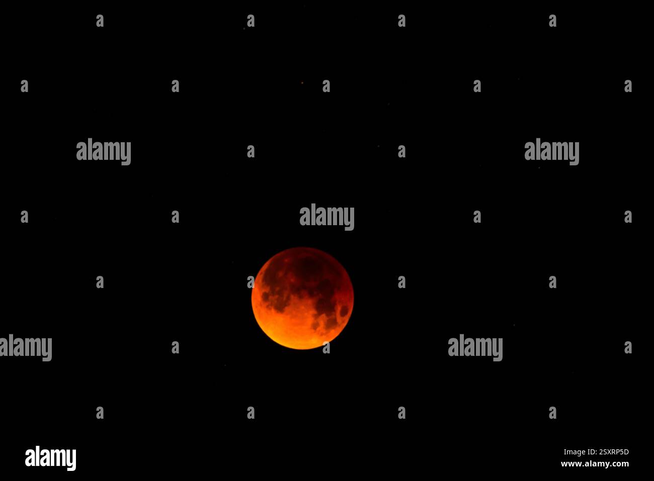A glowing blood moon during a partial lunar eclipse at night. Stock Photo