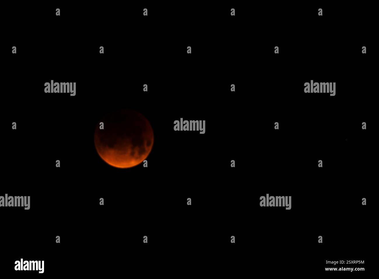 A glowing blood moon during a partial lunar eclipse at night. Stock Photo