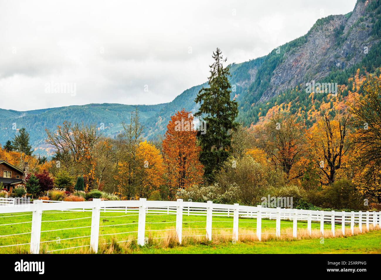 Idyllic farm with fall colors and a white fence against hillside Stock ...