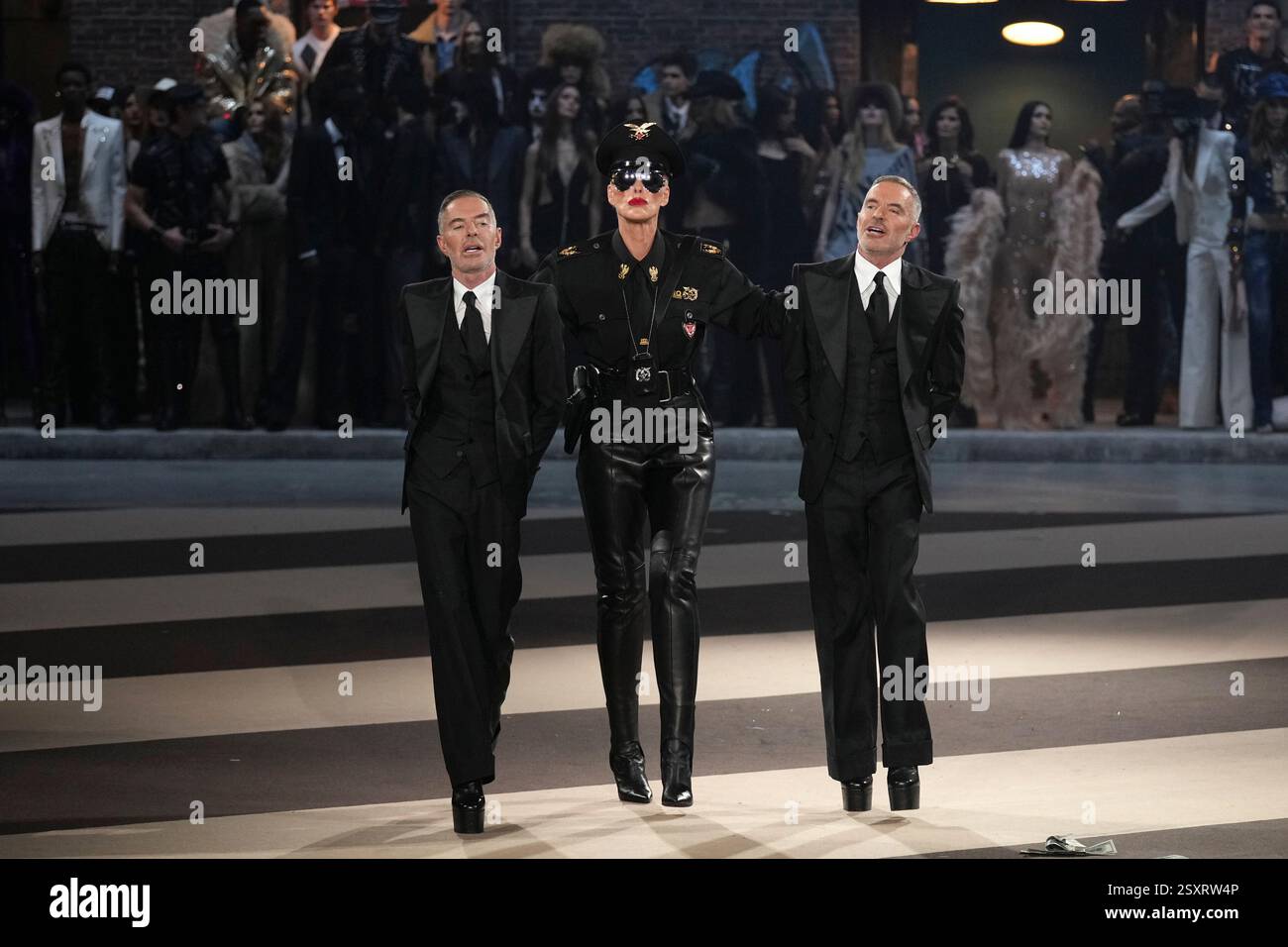 Denmark S Actress Brigitte Nielsen Centre Walks With Designers Dean Denmarks Actress Brigitte Nielsen Centre Walks With Designers Dean Caten Left And Dan Caten During The Dsquared2 Fallwinter 2025 2026 Mens And Womens Collection Presented In Milan Italy Tuesday Feb 25 2025 Ap Photoantonio Calanni 2SXRW4P