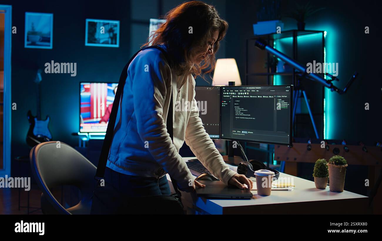Developer holding disposable cup of coffee entering office to implement security measures, protecting company systems and data. IT worker starting job shift, testing and debugging code, camera B Stock Photo