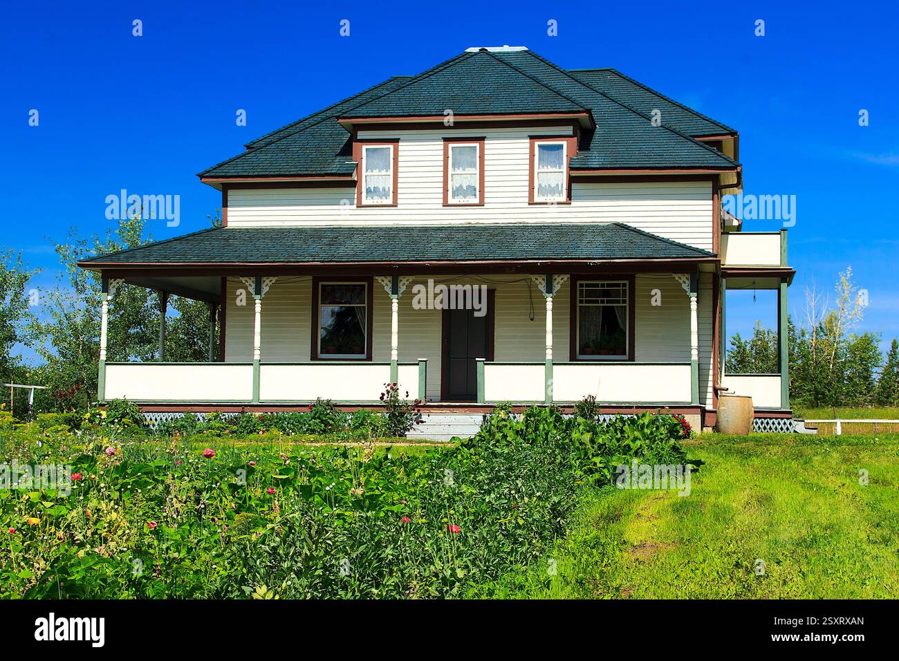 Large house with a green roof. The house is surrounded by a lush green  lawn. The house has a porch and a balcony Stock Photo - Alamy, image size:1300x956
