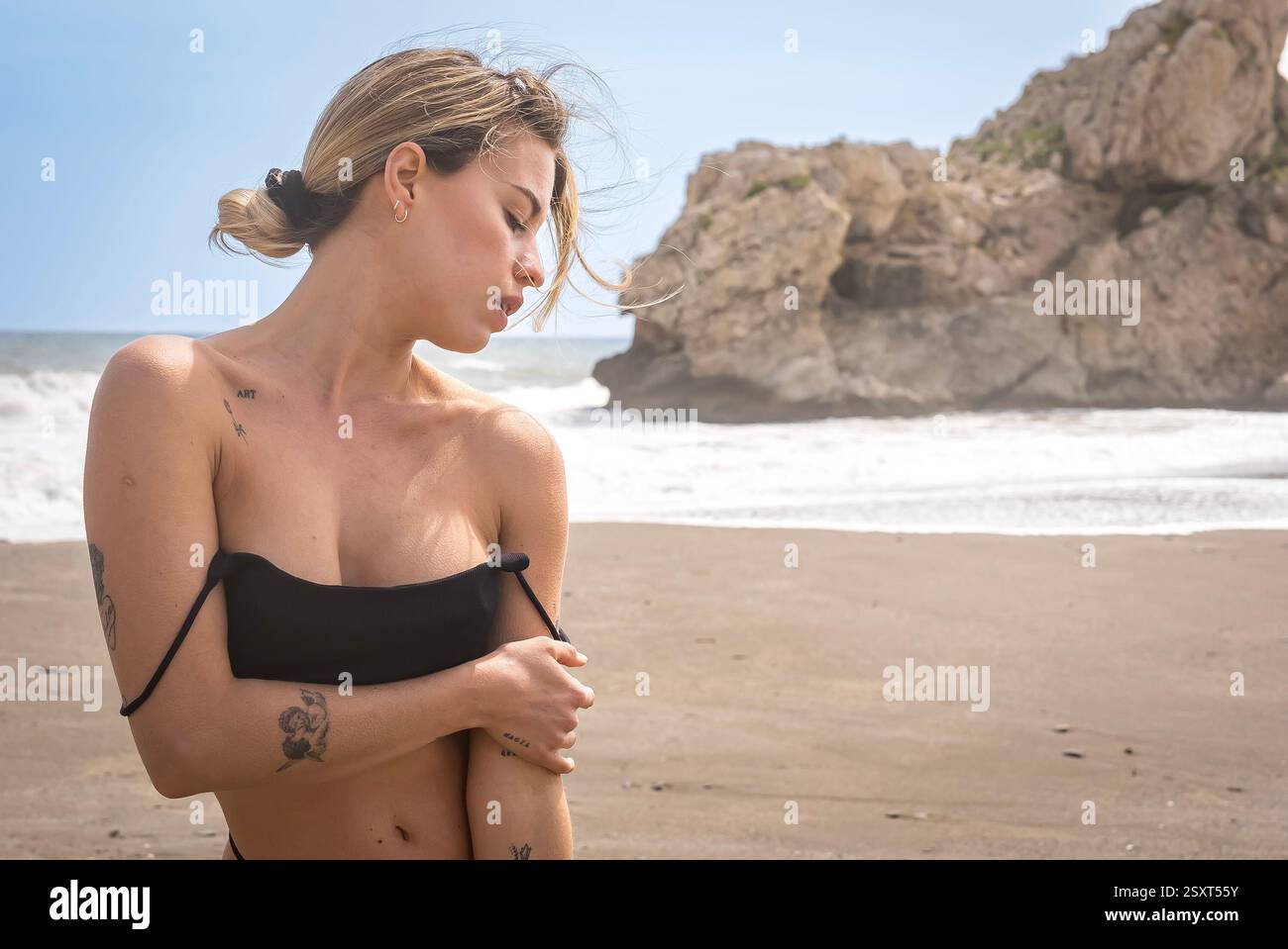 Gorgeous Venezuelan blonde bikini model revels in Alboran Sea's beauty, basking in beach bliss on holiday. Stock Photo