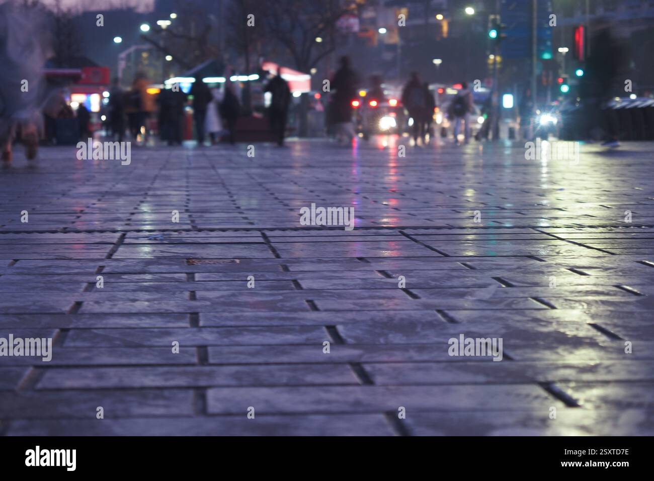 Urban street at dusk with reflections from rain-soaked pavement Stock ...