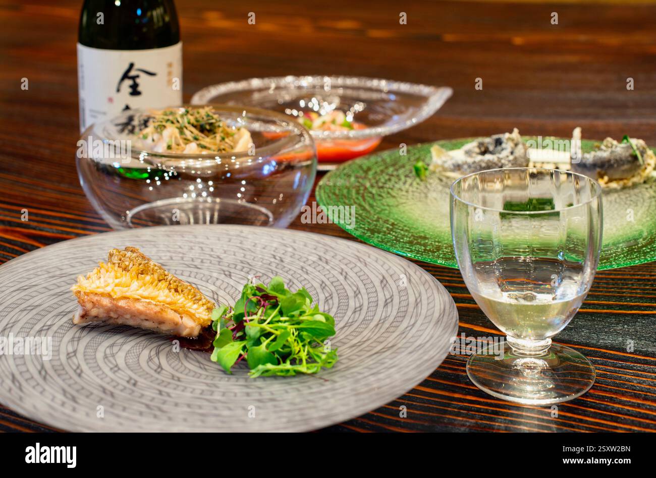 A variety of dishes featuring local ingredients  is served with Japanese sake at Cave Yunoki French restaurant in Toyoma City, Japan Stock Photo