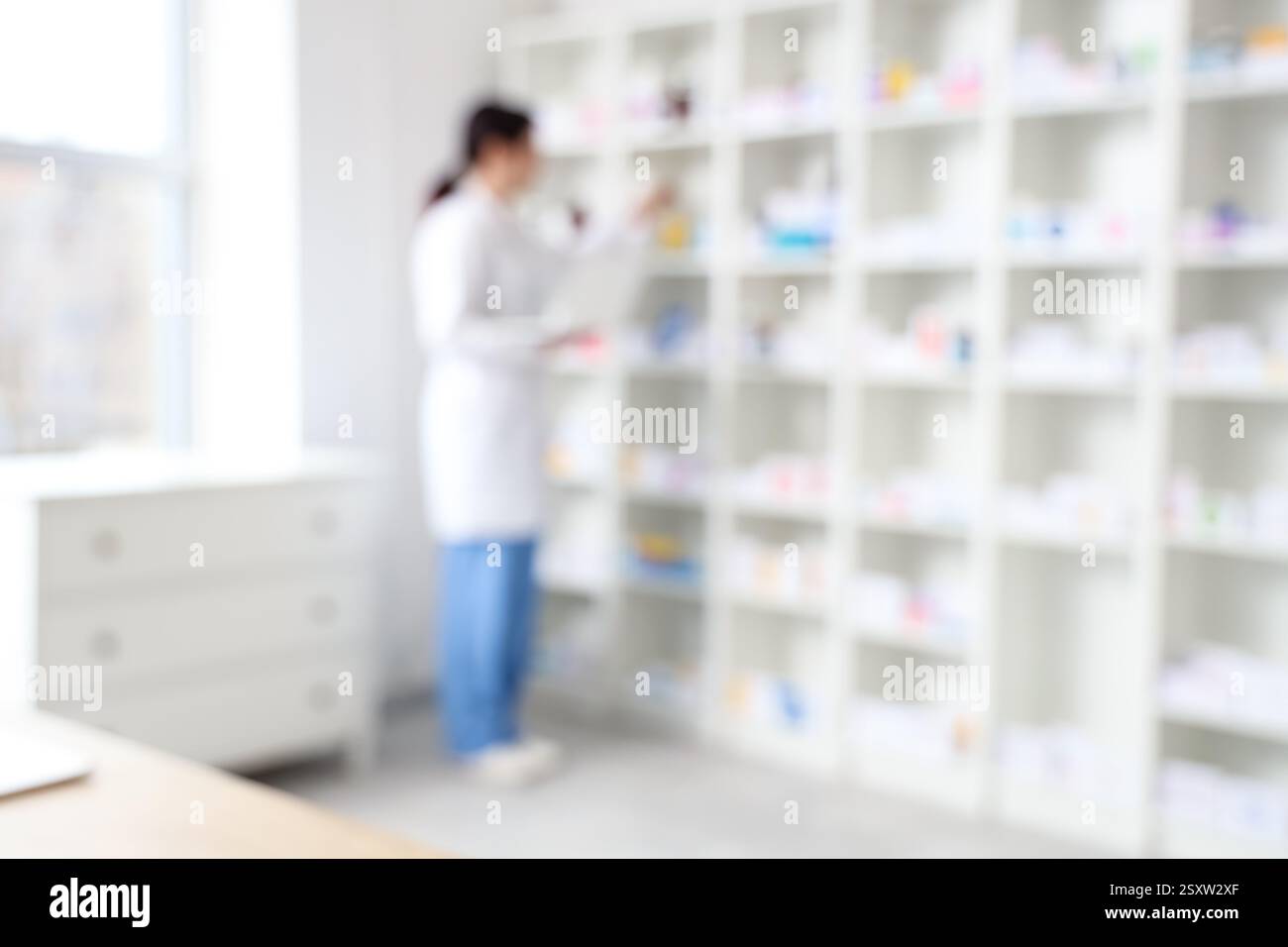 Blurred view of female pharmacist working at pharmacy Stock Photo - Alamy