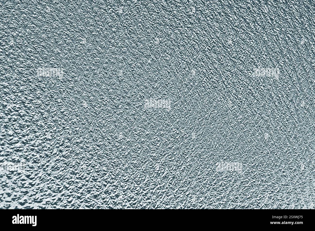 Textured plaster wall creating intriguing light and shadow play Stock Photo