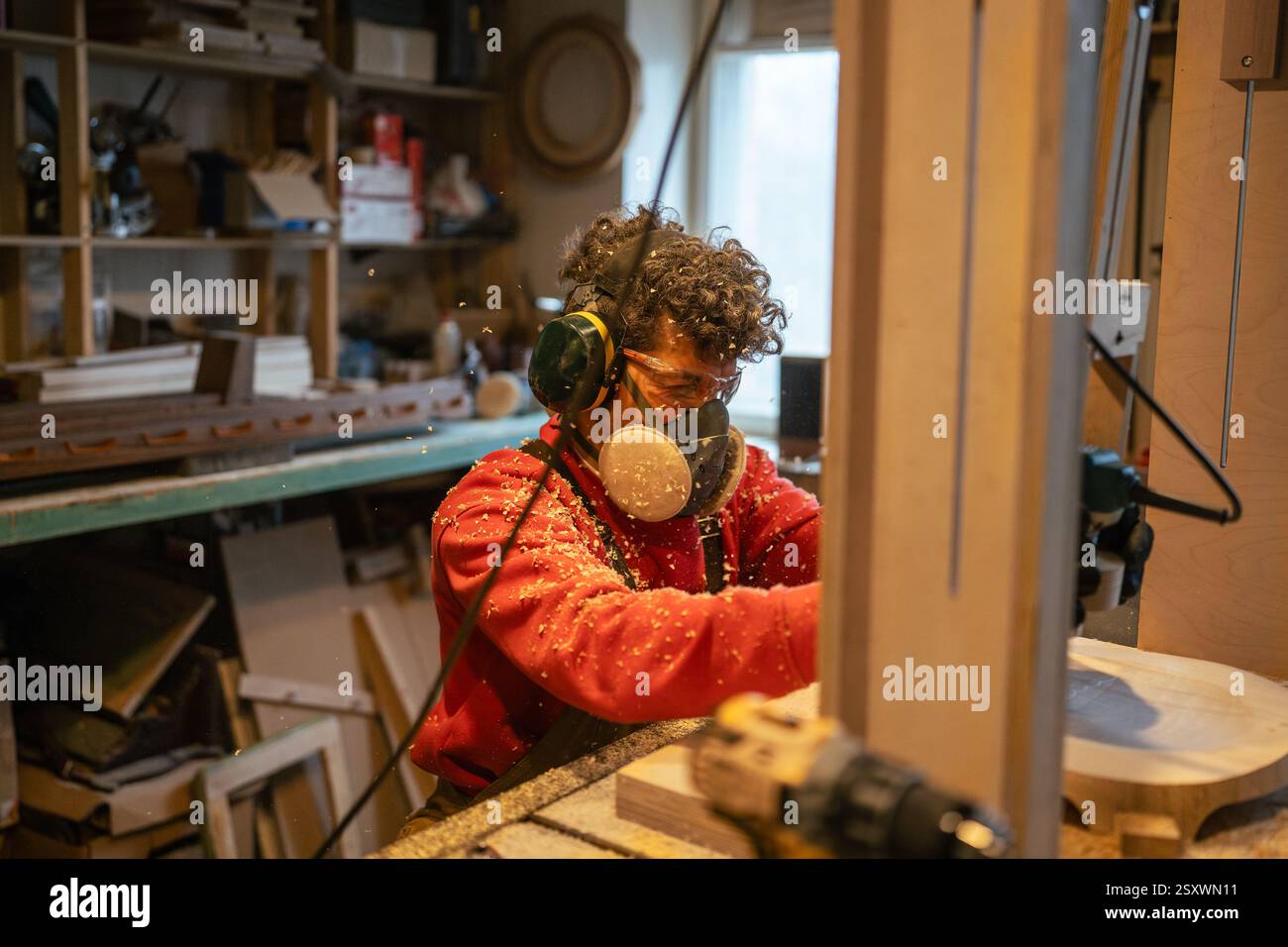 Carpentry workshop craftsman master working. Manual wood milling guy holds tool controlling process Stock Photo