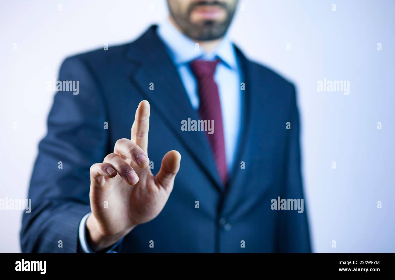 Young business man touching an imaginary screen Stock Photo