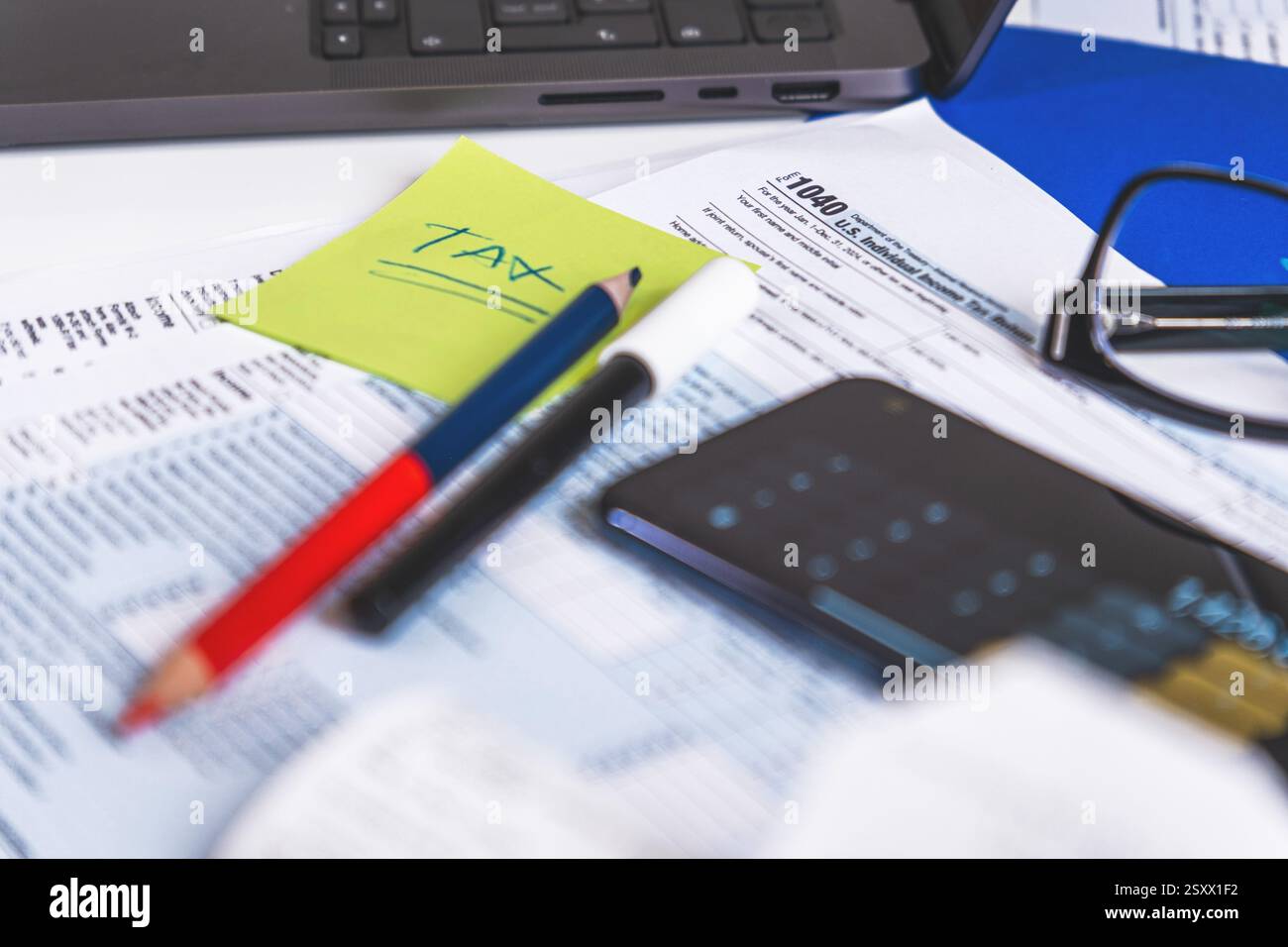 Accountant calculating taxes using calculator app on smartphone Stock Photo