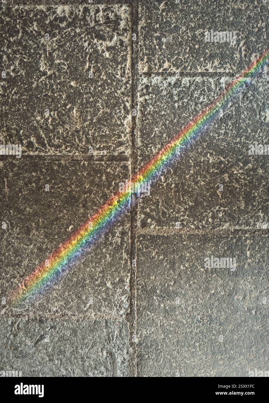View from above rainbow prism over gray stone surface Stock Photo