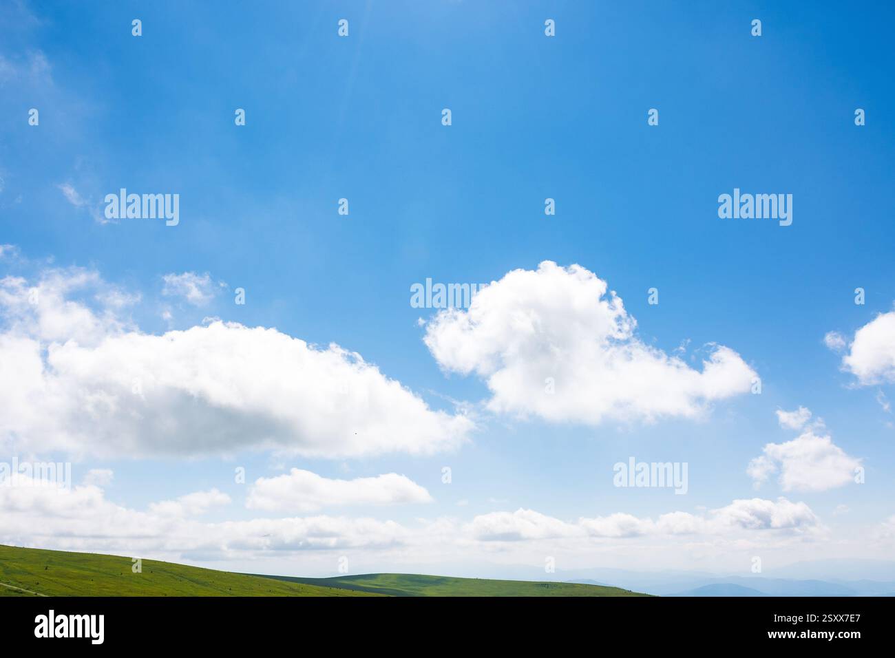 white cumulus clouds on a blue sky. horizon above mountain. wonderful nature background of atmosphere condition in day light. bright summer weather fo Stock Photo