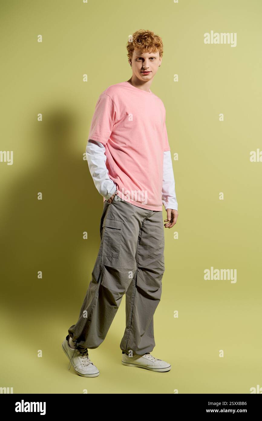 Stylish young man poses casually against a vibrant green wall Stock ...