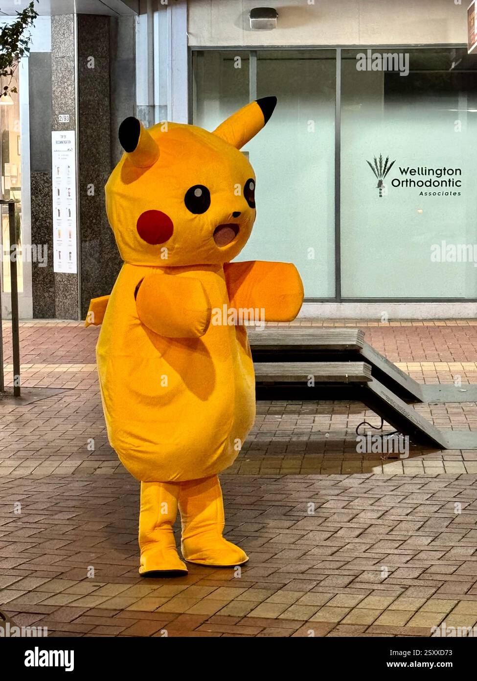 Person wearing Pokemon Pikachu character costume in the street - Smartphone Captured Stock Image