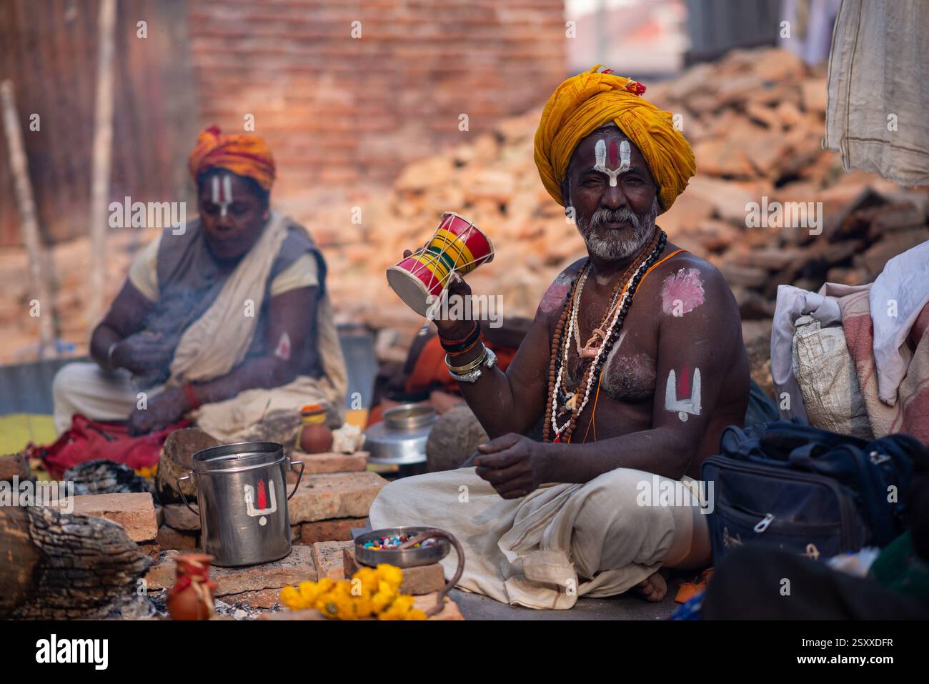 A sadhu or priest plays damaru, a traditional musical instrument during ...