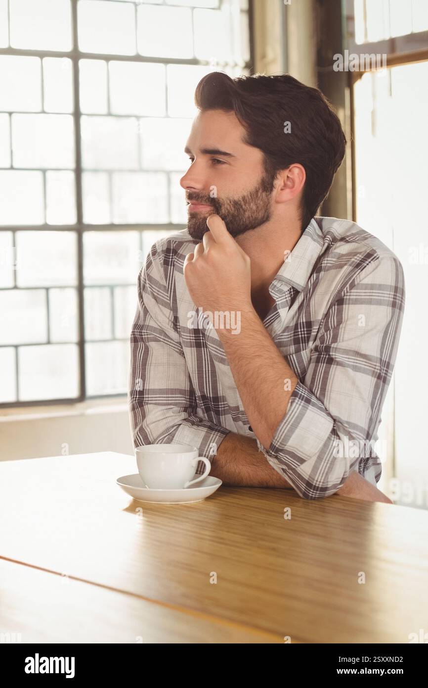 Bearded man in plaid shirt enjoying coffee at trendy cafe Stock Photo