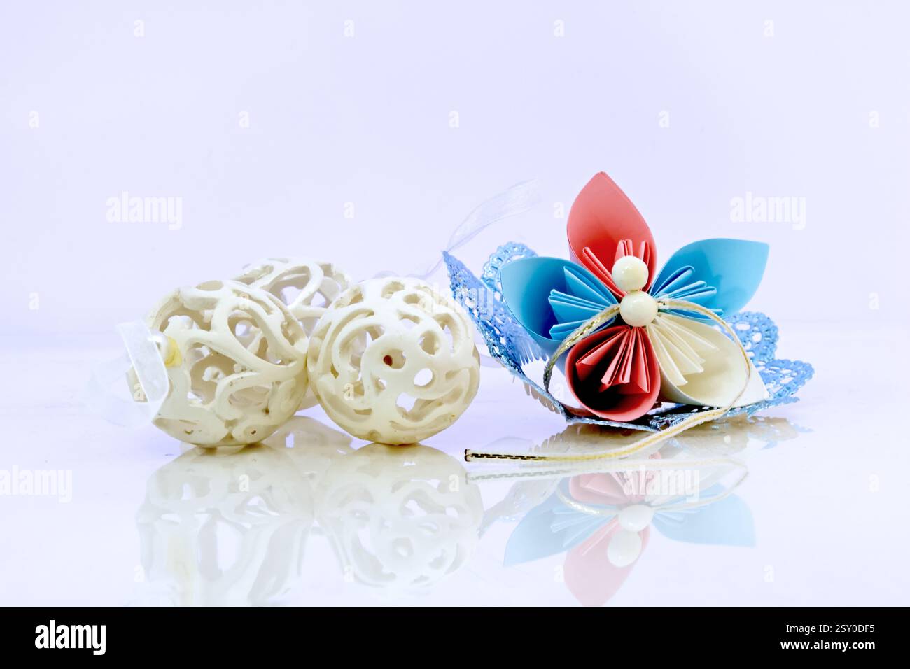 Three white plastic easter eggs and paper flower Stock Photo