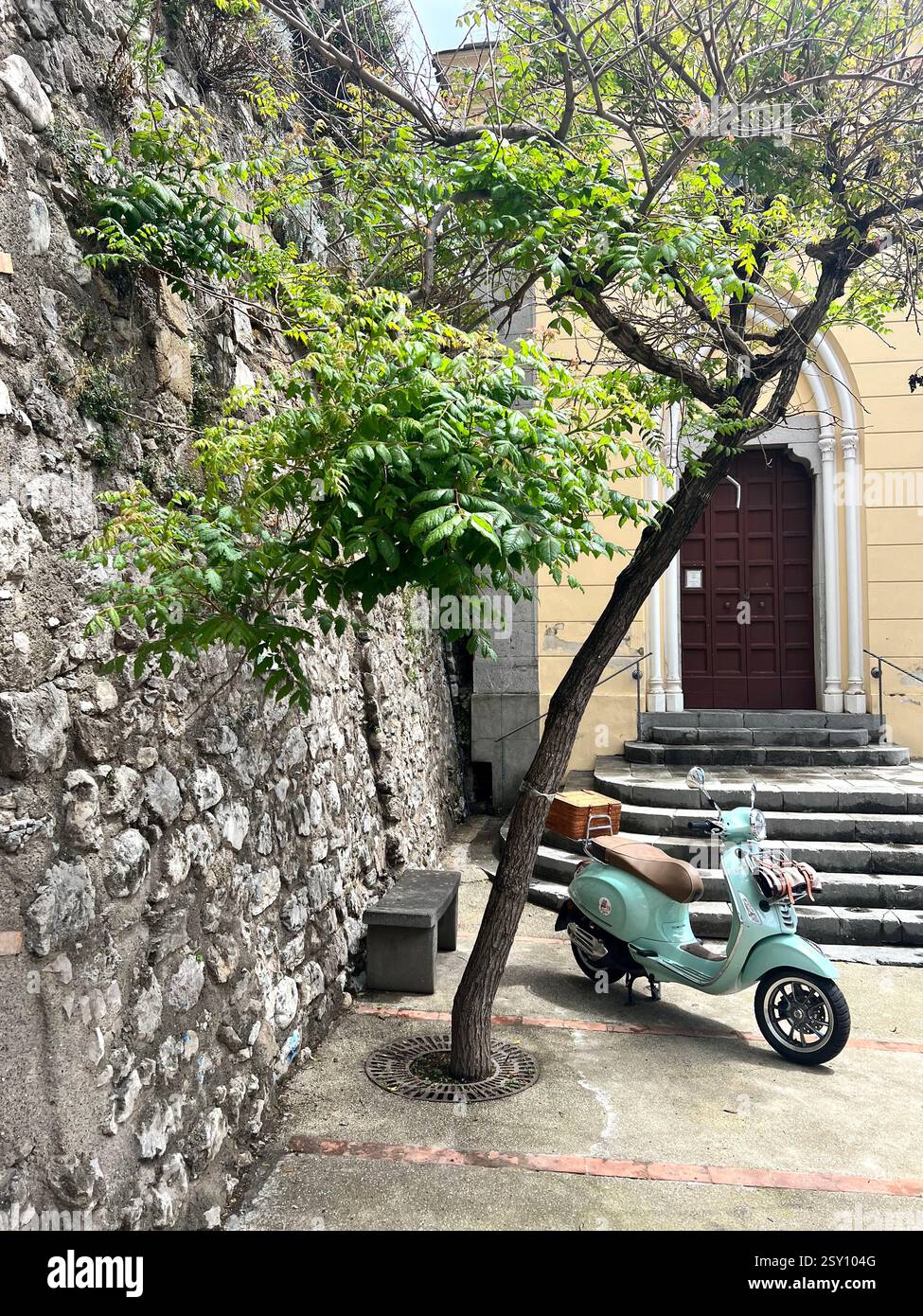 Vintage Mint Green Scooter Parked by a Historic Stone Wall - Smartphone Captured Stock Image