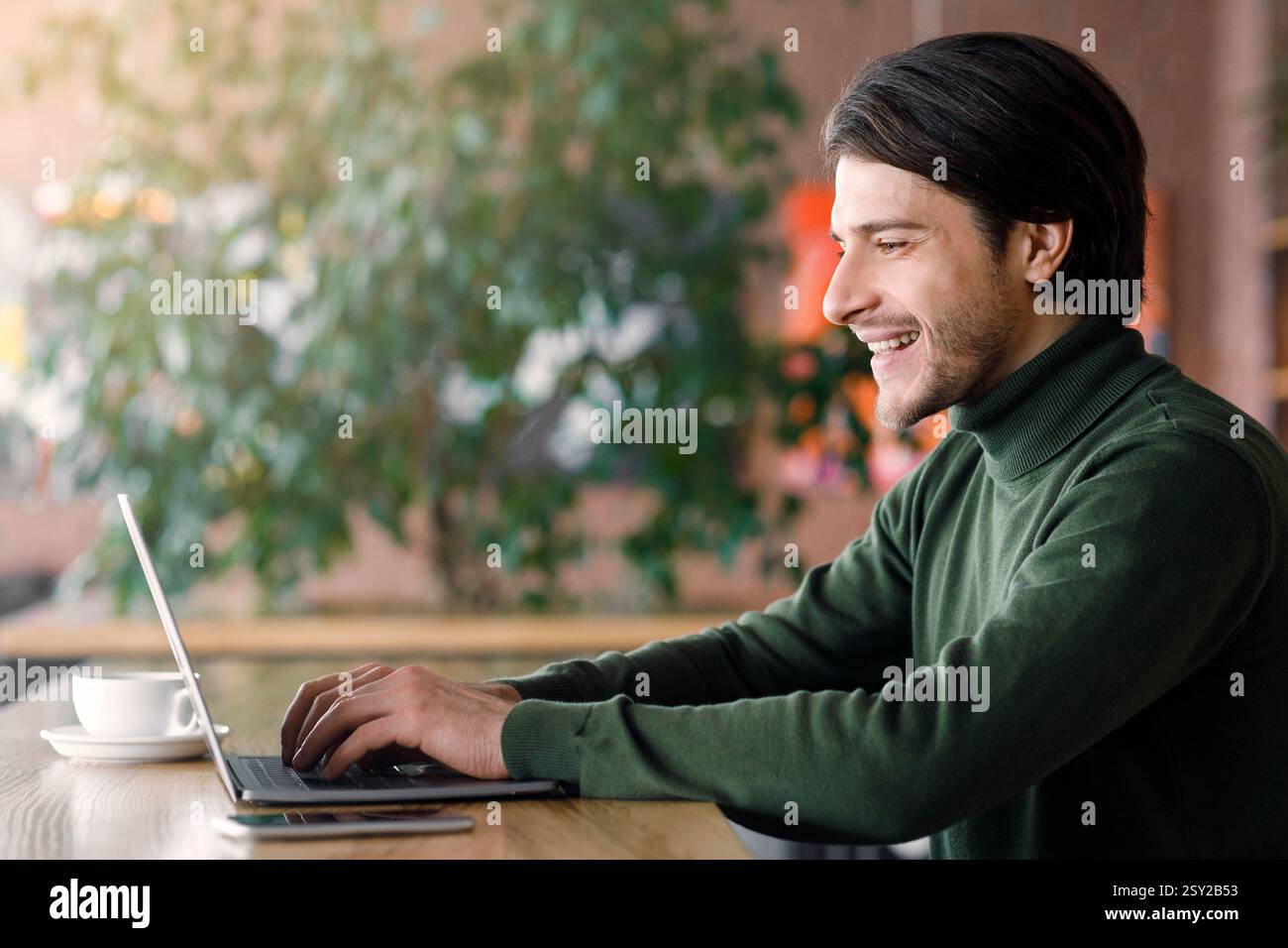 Successful web-designer working at cafe, using laptop Stock Photo
