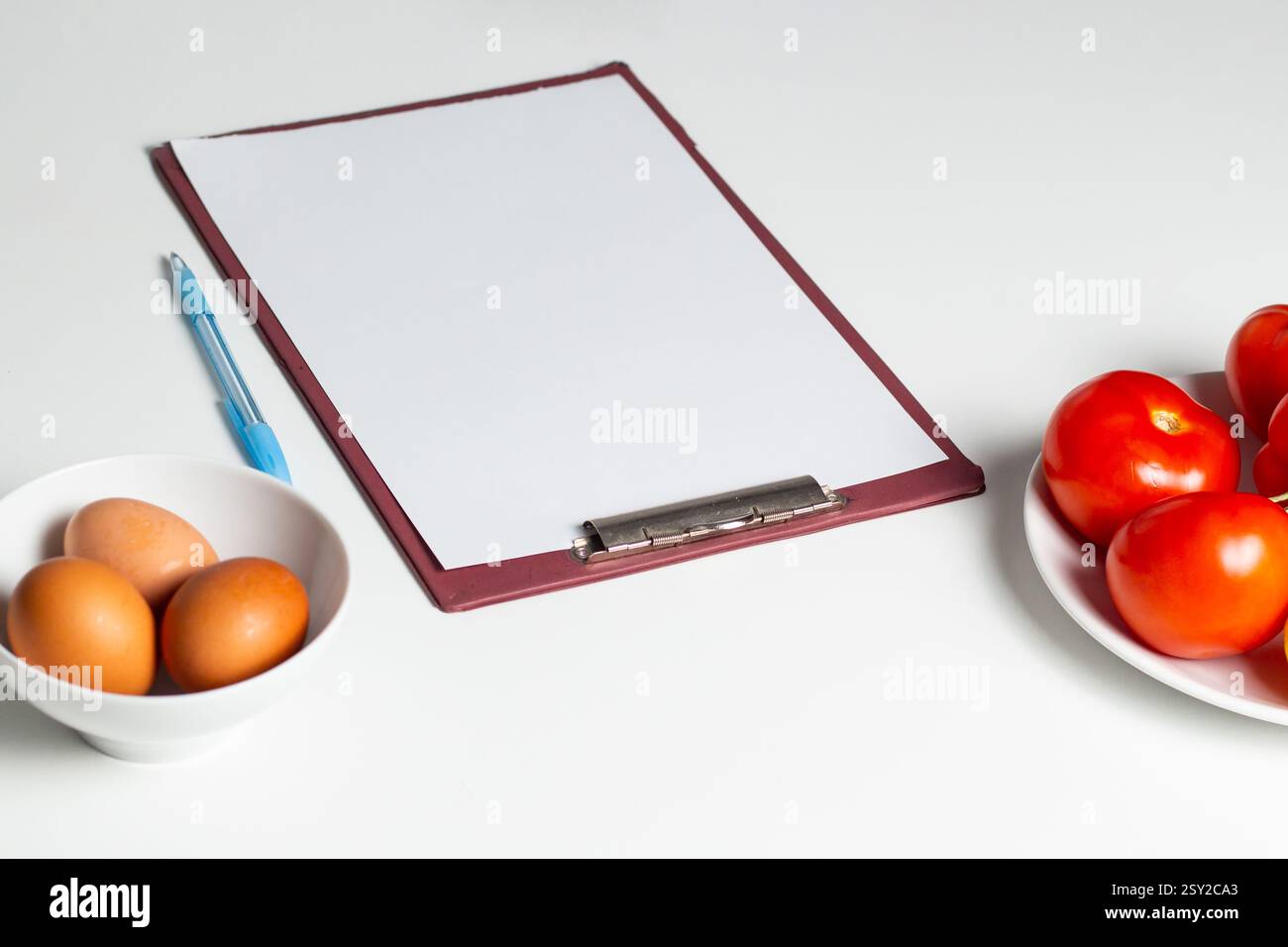 Blank mock up of diet plan, diet menu. Paper with copy space on table with vegetables and eggs. Preparing healthy eating plan. Stock Photo