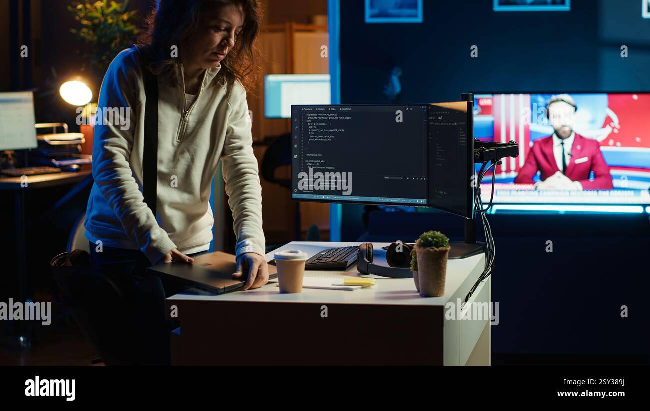 Developer holding disposable cup of coffee entering office to implement security measures, protecting company systems and data. IT worker starting job shift, testing and debugging code, camera A Stock Photo