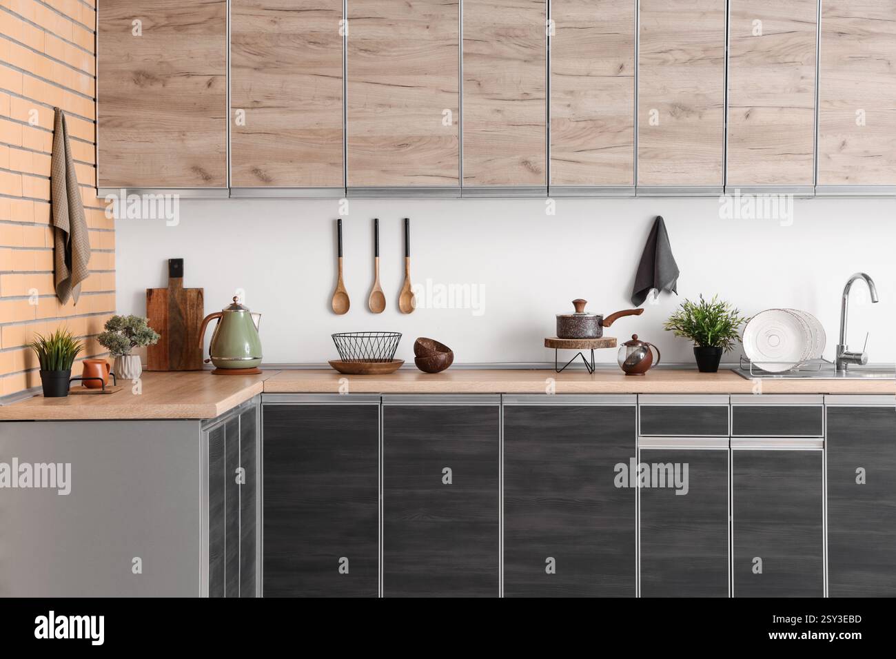 Interior of modern kitchen with black counters and utensils near white ...