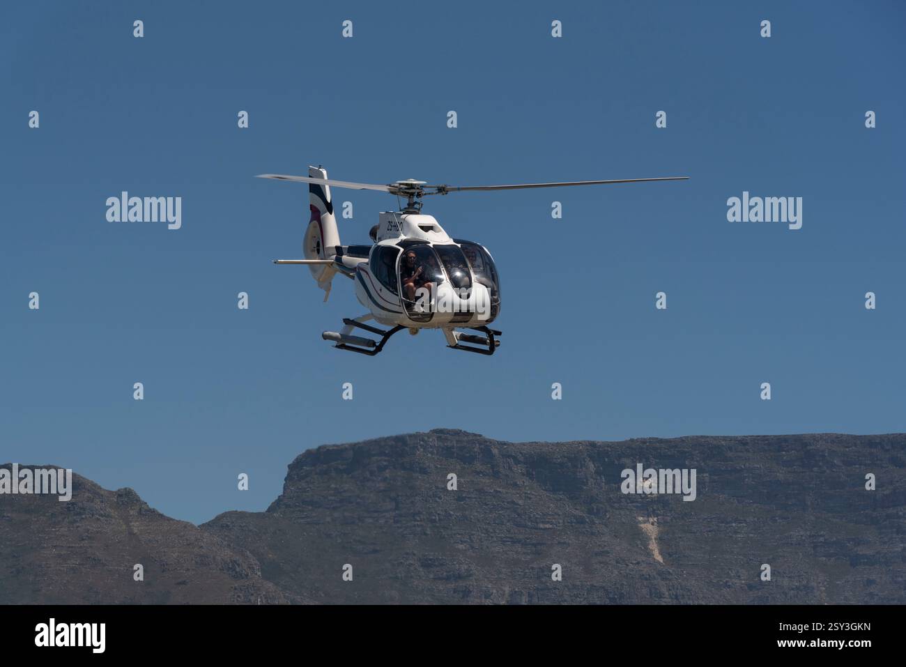 Cape Town South Africa. 25.12.2024.  Helicopter with tourists aboard on finals to land with Table Mountain in background. Stock Photo