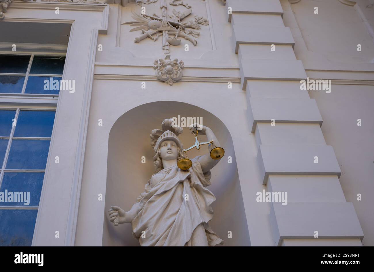 A low-angle, eye-level shot of the Linderhof Palace rooftop, featuring a sculpture of Atlas holding the globe, surrounded by other statues and ornate. Stock Photo