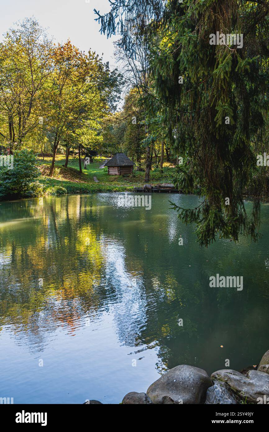 Calm waters mirror the vibrant hues of autumn foliage as sunlight ...