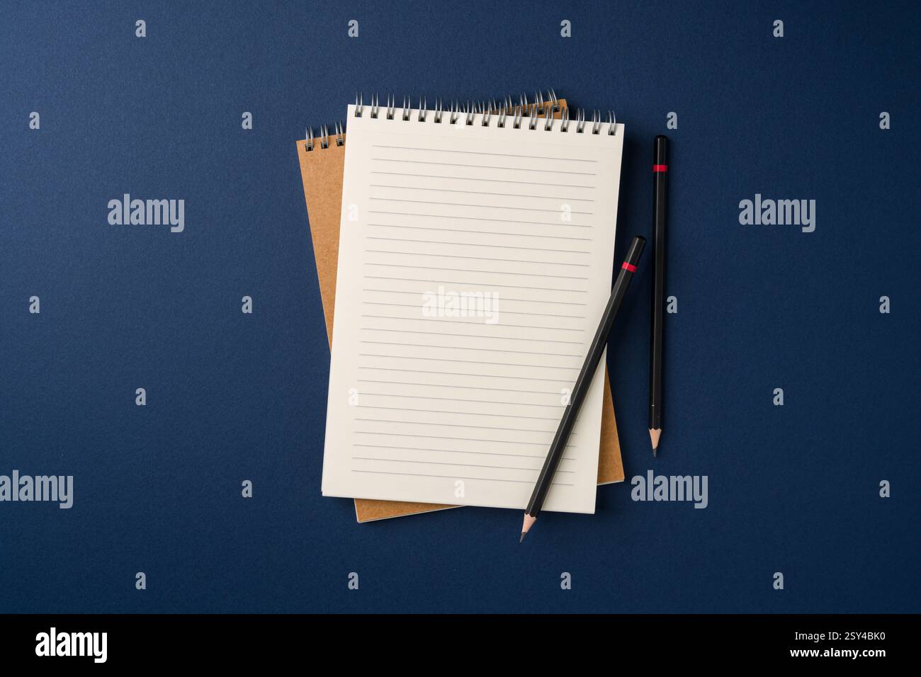 Top view of notebook and pencil on blue background Stock Photo