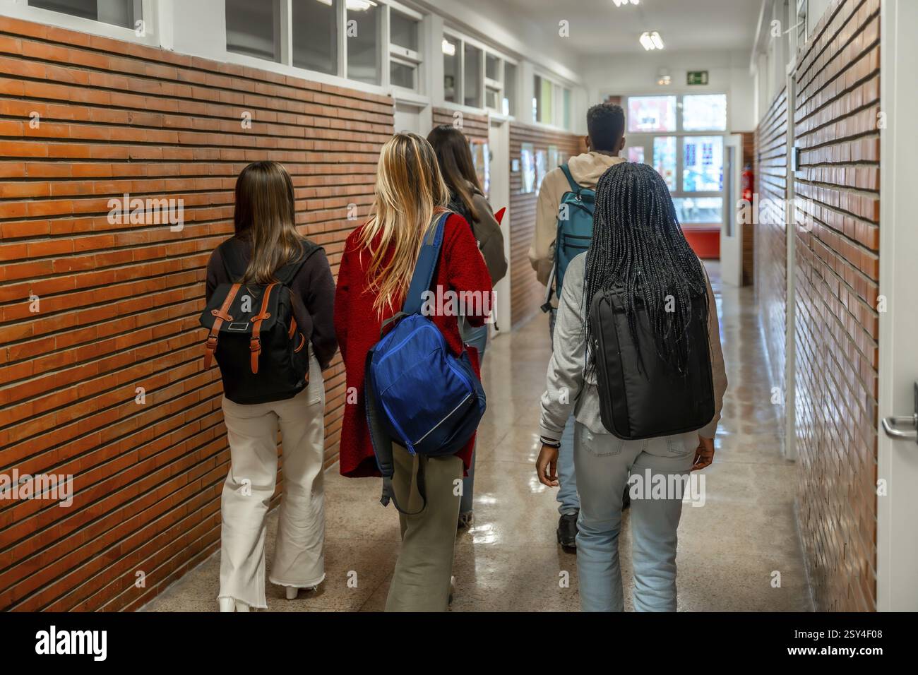 Group of diverse high school or university students walking down school ...