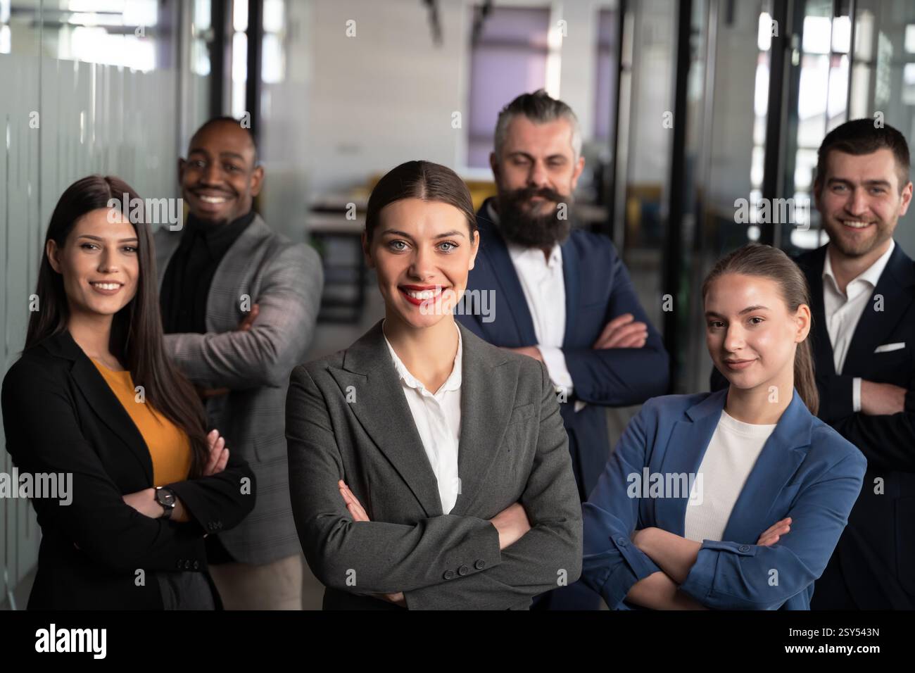 Diverse business team standing together in a modern office, smiling ...