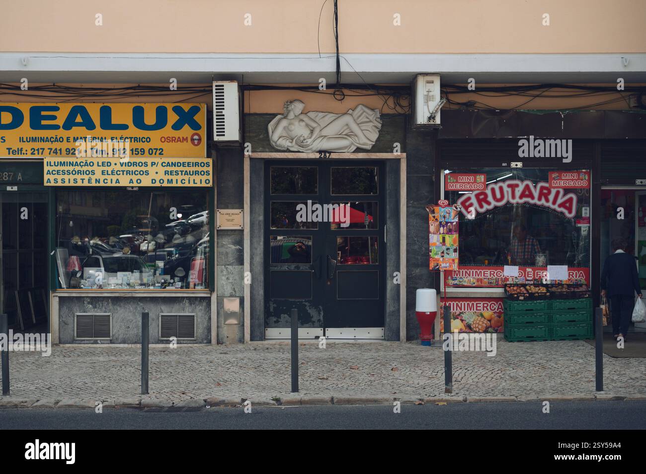 A Lisbon streetscape featuring a fruit shop, an electrical supply store ...