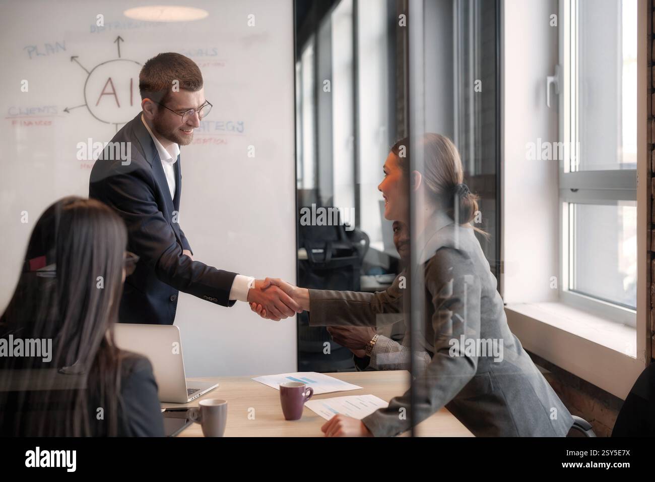 Business professionals shaking hands during a meeting in a modern ...