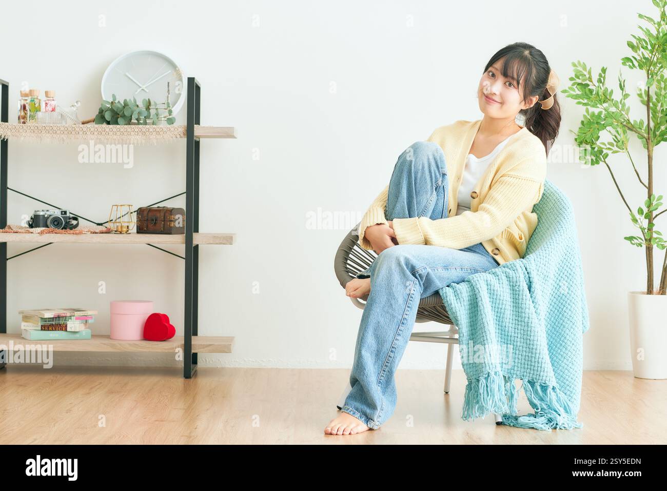 Japanese Woman Sitting On Chair In Living Room Stock Photo - Alamy
