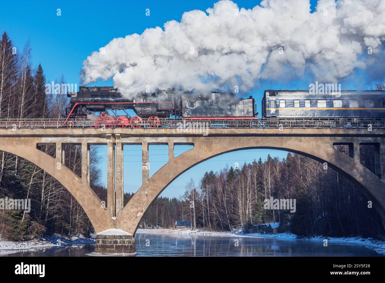 Retro steam train moves above the river Stock Photo - Alamy