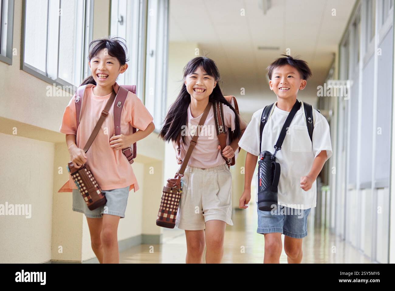 Japanese Kids Walking Down A School Hallway Stock Photo