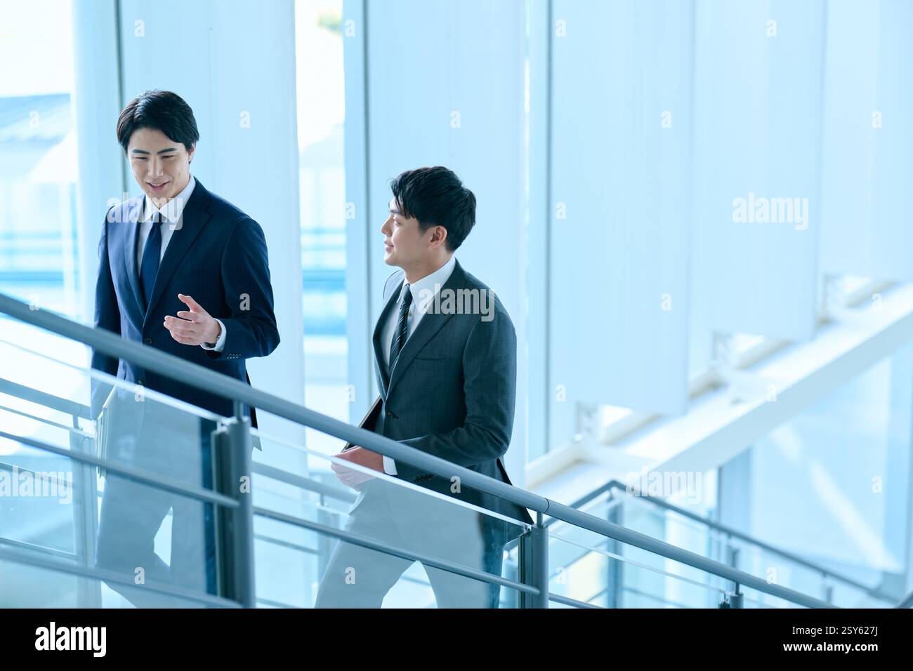 Two Japanese Businessmen Walking Up A Stairwell Stock Photo - Alamy
