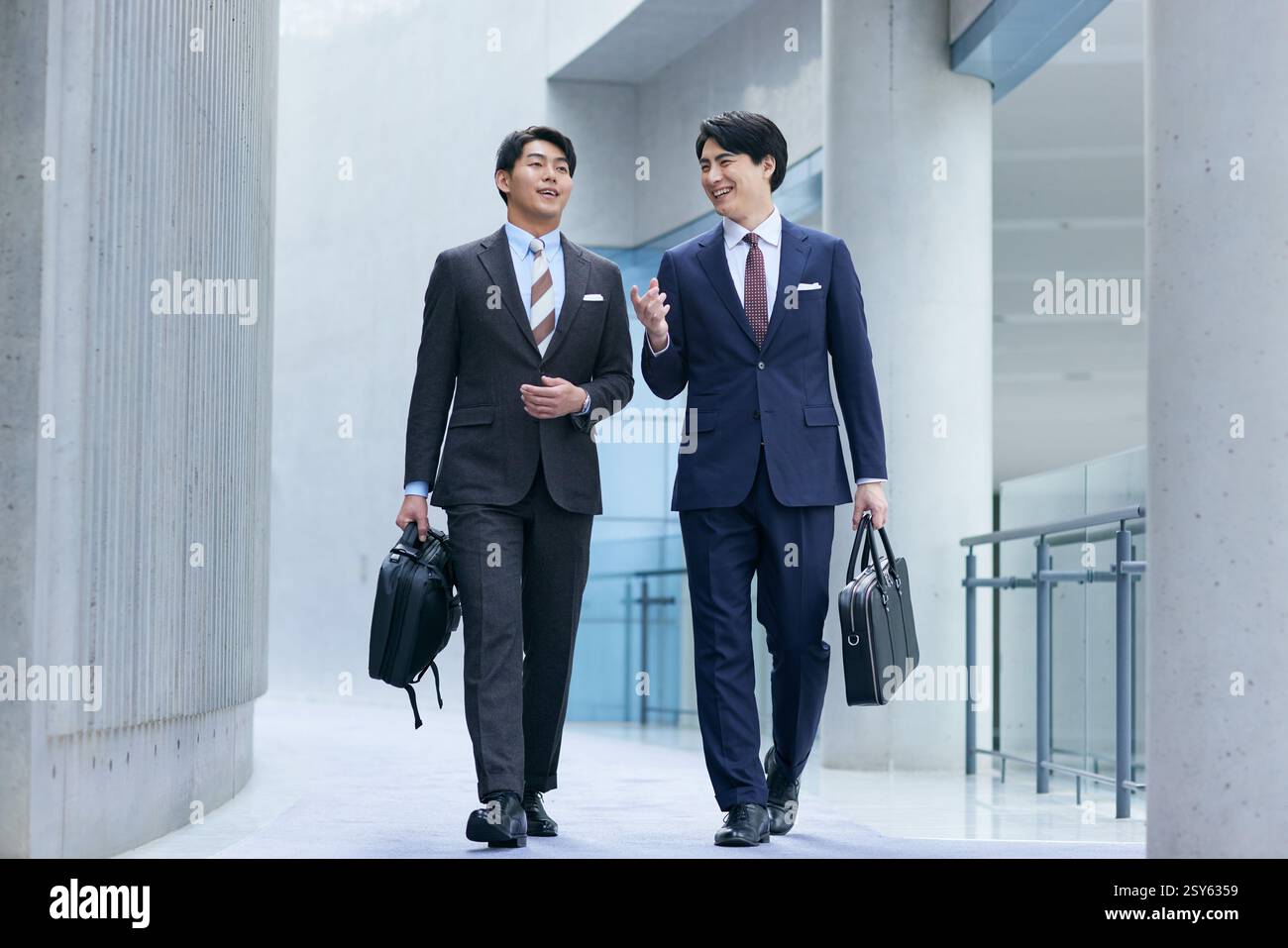 Two Japanese Businessmen Walking Down An Empty Hallway Stock Photo - Alamy