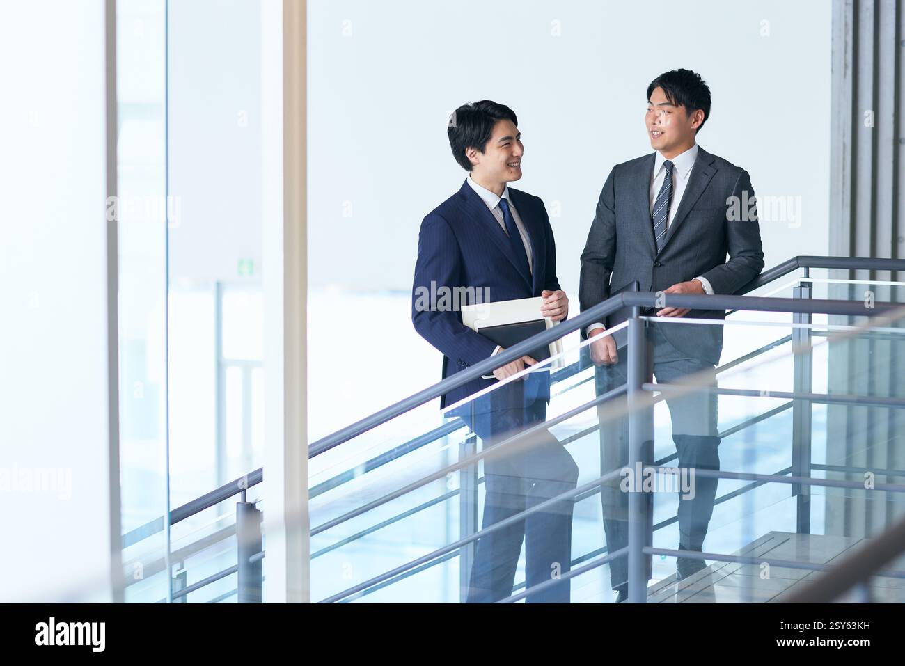 Two Japanese Businessmen Walking Down A Stairwell Stock Photo - Alamy
