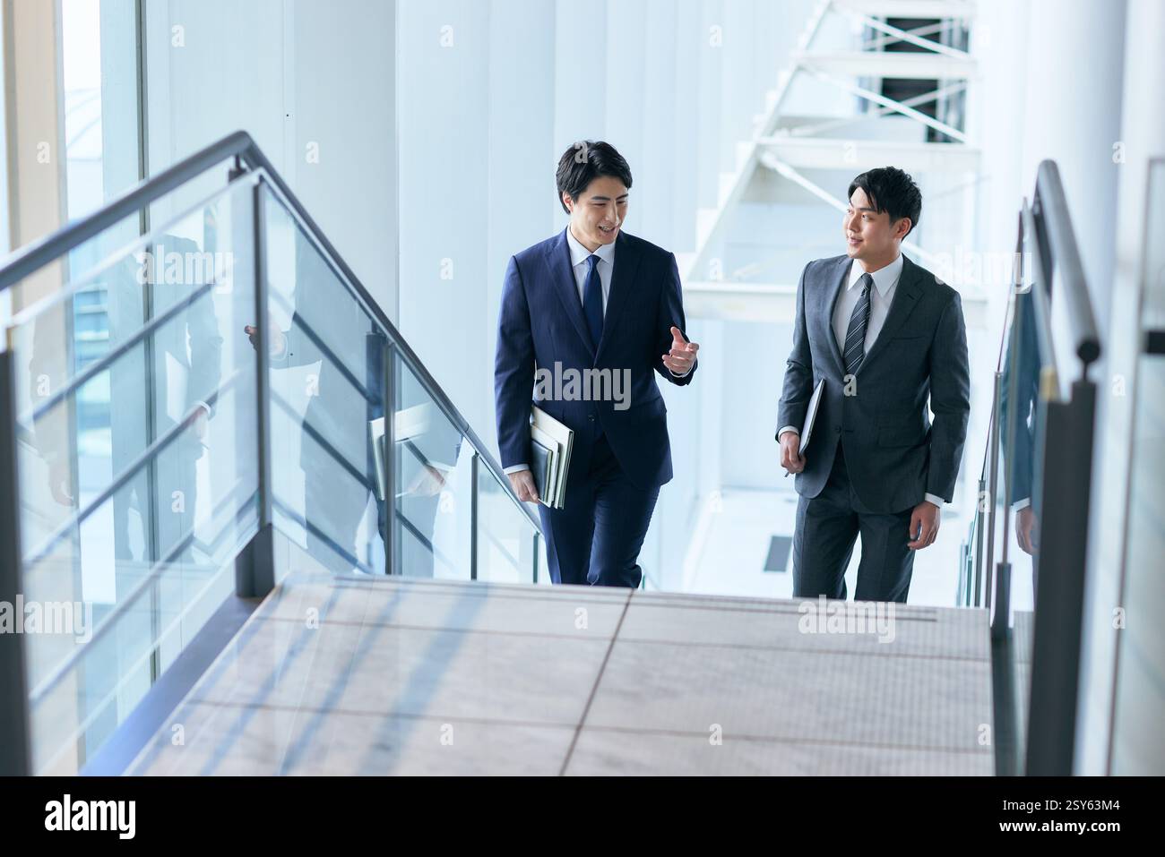 Two Japanese Businessmen Walking Up A Stairwell Stock Photo - Alamy