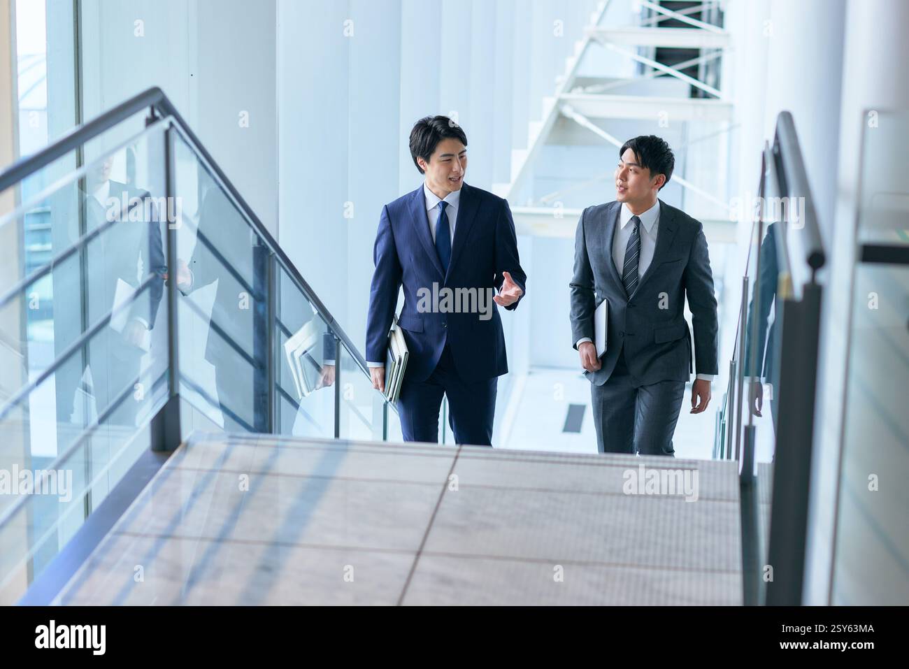 Two Japanese Businessmen Walking Up A Stairwell Stock Photo - Alamy